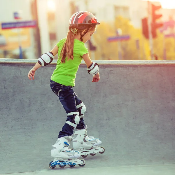 Klein meisje in helm op rolschaatsen — Stockfoto