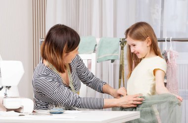Anne ve kızı elbise dikiyor.