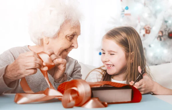 Abuela con nieta decorando regalos — Foto de Stock