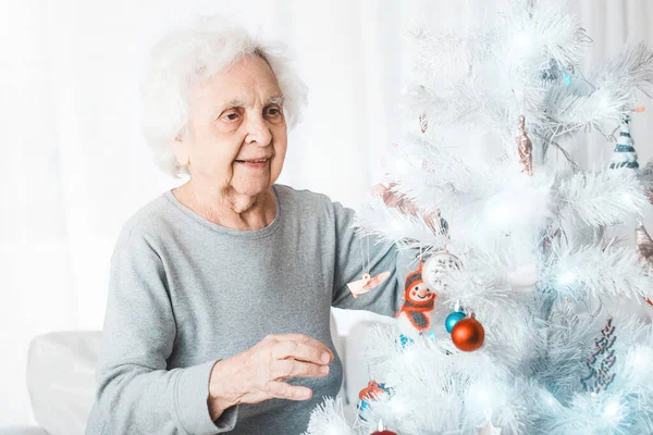 Mujer mayor decorando árbol de Navidad — Foto de Stock