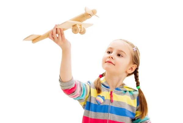 Menina sorridente brincando com avião de brinquedo de madeira — Fotografia de Stock