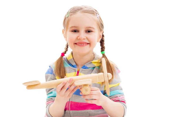 Smiley girl playing with wooden toy plane Royalty Free Stock Photos