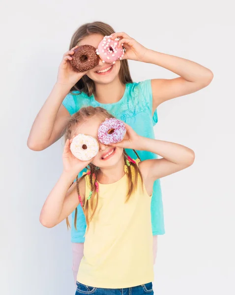 Hermanas haciendo mueca con rosquillas — Foto de Stock