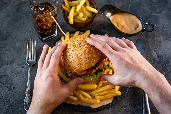 Male hands holding burger — Stock Photo, Image