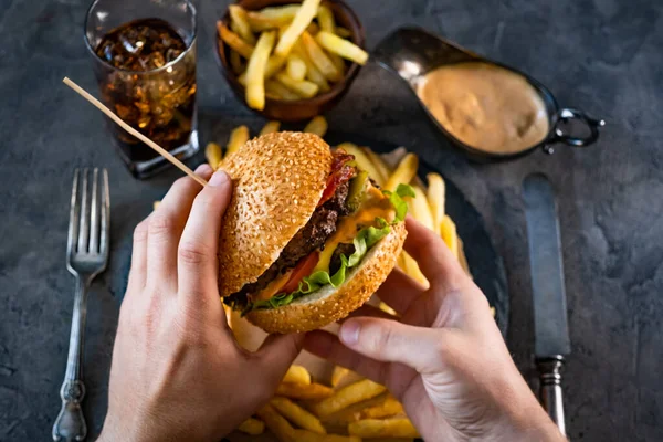 Male hands holding burger — Stock Photo, Image