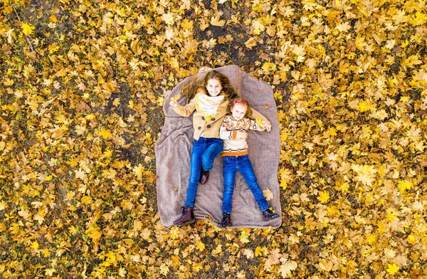 Meninas felizes deitado no tapete de piquenique — Fotografia de Stock