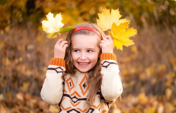 Kind spielt mit Herbstblättern — Stockfoto