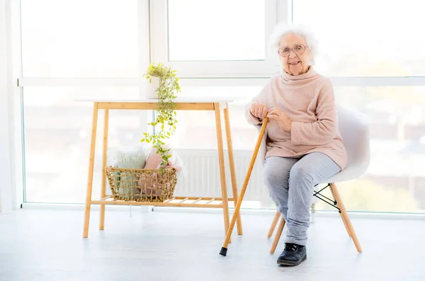 Sonriente abuelita sentado en la silla — Foto de Stock