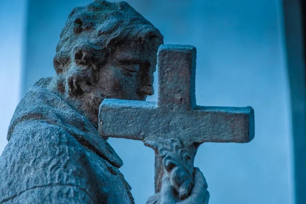 Скульптура человека с крестом — стоковое фото