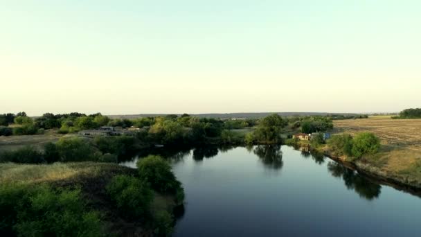 Річка тече між літніми полями — стокове відео