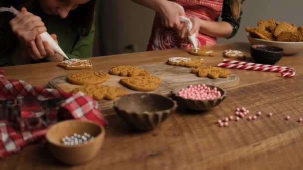 Novias decorando figuras de pan de jengibre usando bolsas culinarias — Vídeo de stock