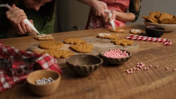 Girlfriends decorating gingerbread figures using culinary bags — Stock Video