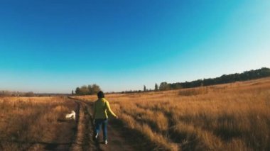 Golgen Retriever köpeğiyle yürüyen genç bir kadın.