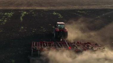 Traktör tarlayı kara toprakla sürüyor.