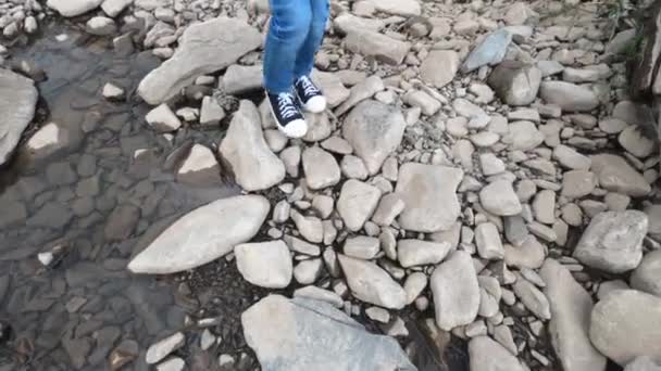 Kleines Kind überquert den Fluss mit dem Stein — Stockvideo