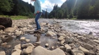 Küçük çocuk nehri taşla geçti.