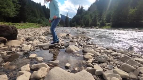 Kleines Kind überquert den Fluss mit dem Stein — Stockvideo