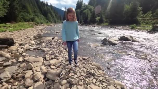 Kleines Kind überquert den Fluss mit dem Stein — Stockvideo