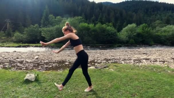 Teenage girl cartwheeling on mountain meadow — ストック動画