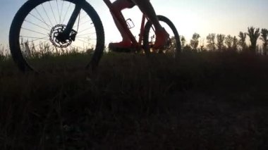 Gün batımında bisiklet süren bir adam