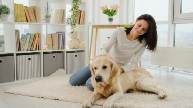 Tatlı Golden Retriever köpeğini okşayan bir kız