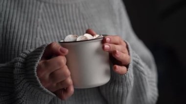 Bardaktan sıcak kakao içen kadın.