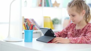 Küçük kız öğrenmek için dijital tablet kullanıyor