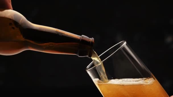 Bier uit de fles in glas gieten — Stockvideo
