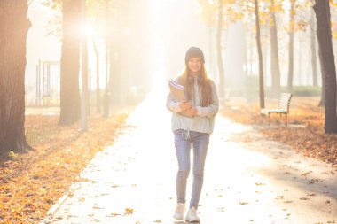 Park yolunda gülümseyen kız.