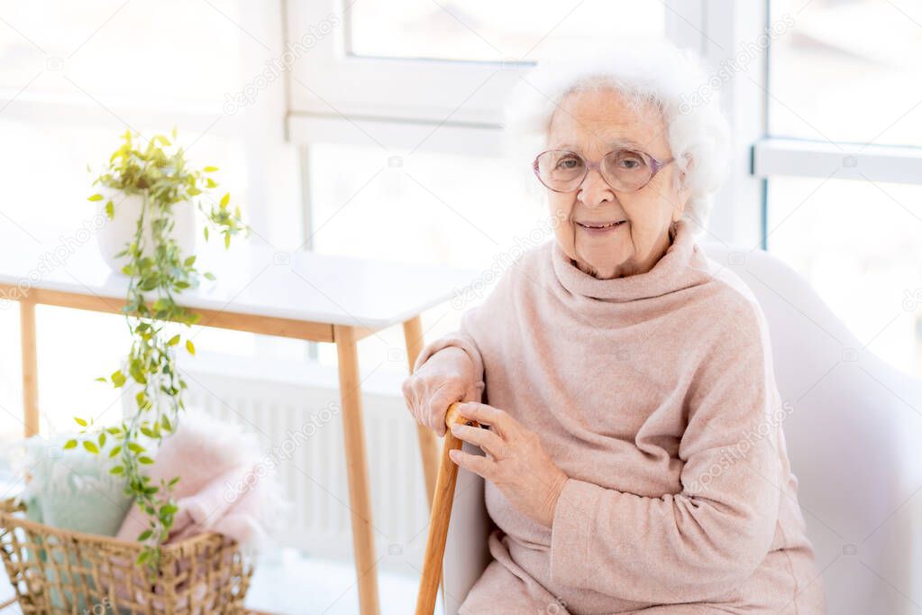 Happy old woman in light interior