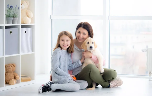 Woman and girl holding dog — Stock Photo, Image