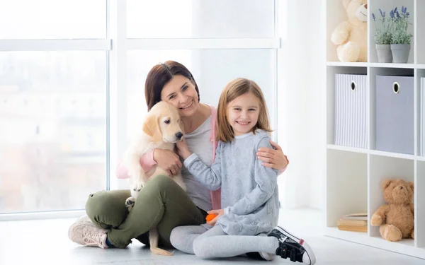 Mother and daughter embracing dog — Stock Photo, Image