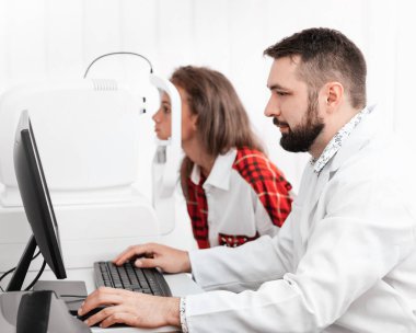 Güzel hastayı muayene eden göz doktoru.