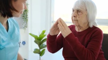 Senior patient speaking with caregiver woman