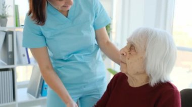 Baş kadın hemşirenin yanında oturuyor.