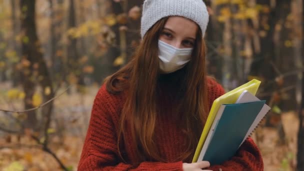 Teenage girl in mask on park background — Stockvideo