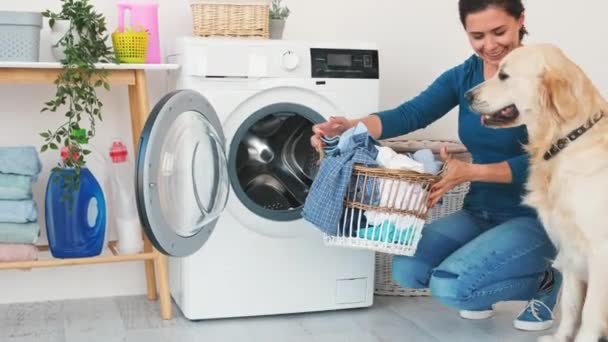 Woman with dog loading washing machine — Stok video