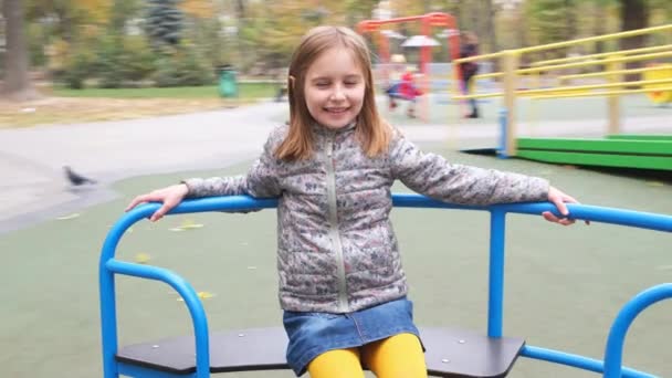 Petite fille au rond-point dans le parc de la ville — Video