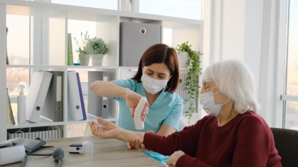 Yaşlı bir hastanın vücut ısısını ölçen doktor. — Stok video