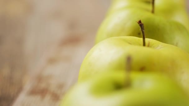 Wiersz zielonych soczystych jabłek na stole — Wideo stockowe