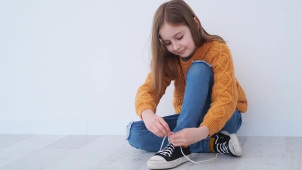 Little girl learning to tie the laces — стоковое видео