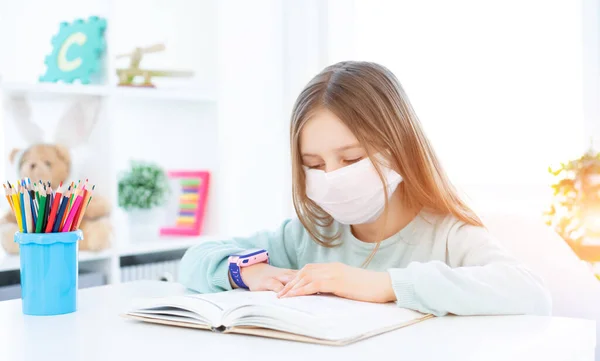 Studentessa in maschera che studia a casa — Foto Stock