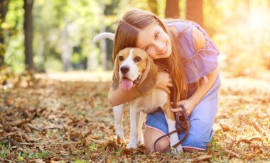 Neşeli çocuk köpeğe sarılıyor.