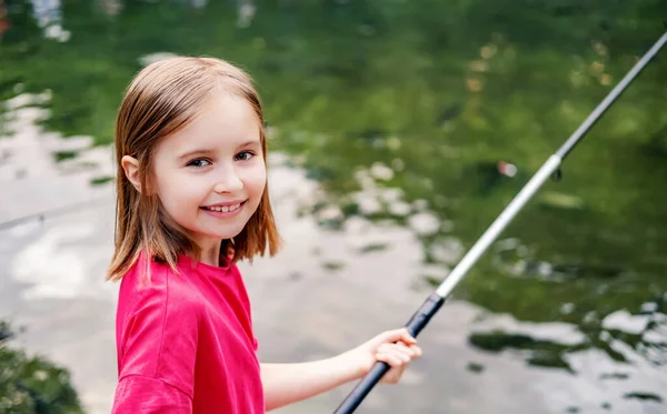 Liten flicka som håller i fiskespö — Stockfoto