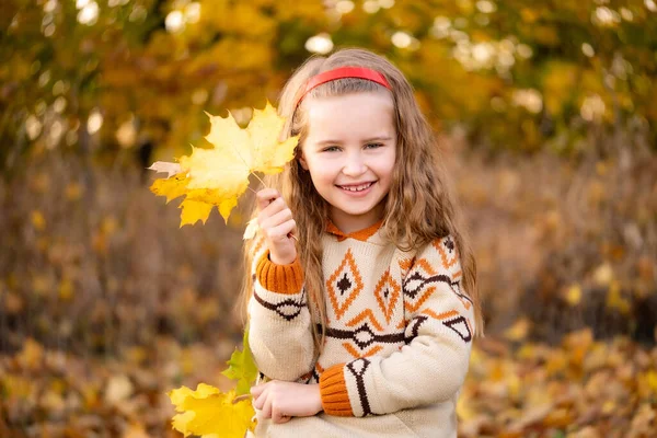 Petite fille souriante aux feuilles d'automne — Photo