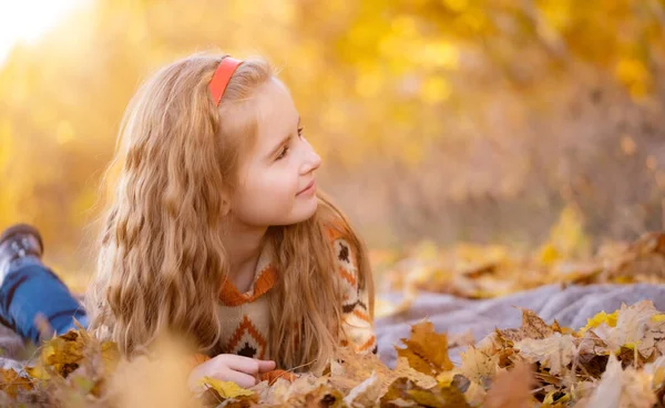 女孩躺在秋天的公园里 — 图库照片