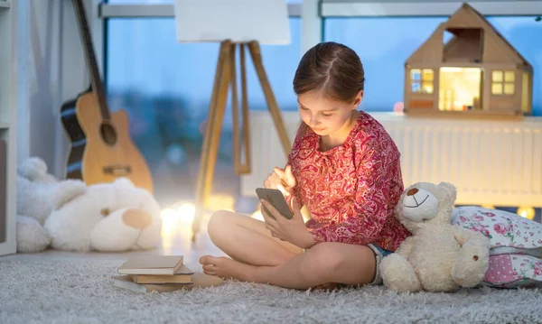 Menina usando smartphone no quarto — Fotografia de Stock