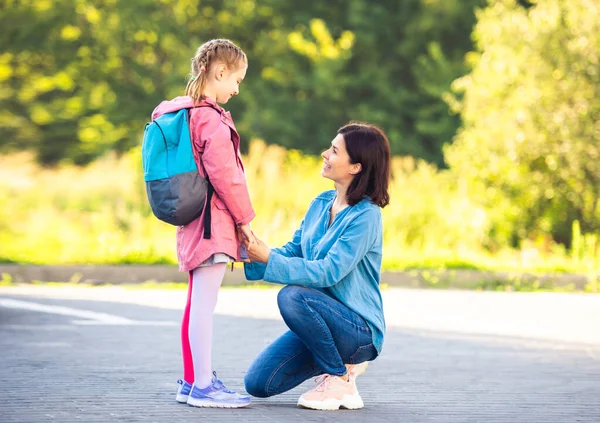Skolflicka säger adjö till mamma innan lektionen — Stockfoto
