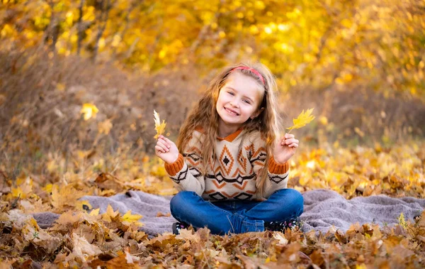 Küçük kız sarı yapraklar tutuyor. — Stok fotoğraf