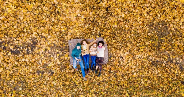 Família deitada em folhas amarelas — Fotografia de Stock